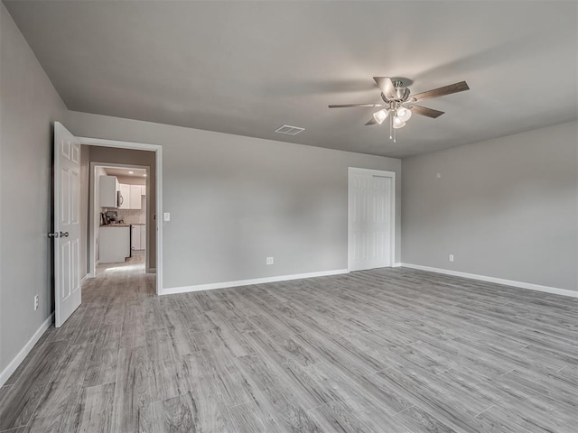 unfurnished room with baseboards, visible vents, and light wood-style floors