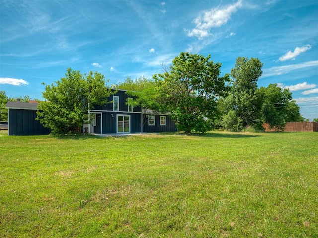 view of yard featuring an outbuilding, fence, and an outdoor structure