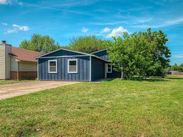 view of home's exterior featuring board and batten siding, concrete driveway, and a lawn