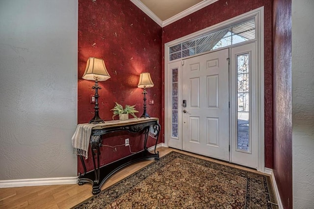 entryway with a textured wall, crown molding, baseboards, and wood finished floors