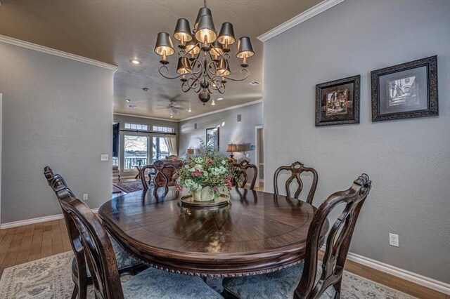 dining space with a textured wall, baseboards, crown molding, and wood finished floors