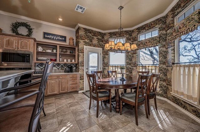 dining area with ornamental molding, visible vents, baseboards, and an inviting chandelier