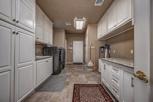 laundry room featuring cabinet space, visible vents, independent washer and dryer, and a sink