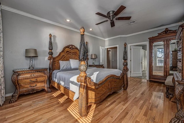 bedroom with light wood finished floors, visible vents, and crown molding