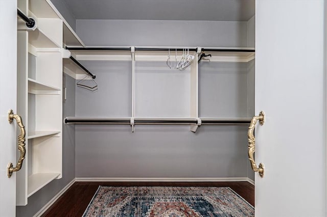 walk in closet with wood finished floors