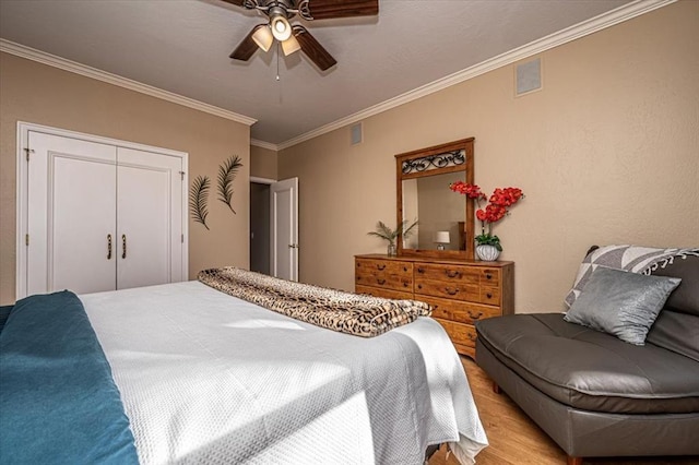 bedroom featuring ceiling fan, light wood-type flooring, visible vents, and crown molding