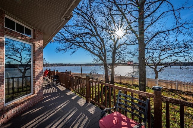 wooden deck featuring a water view and fence