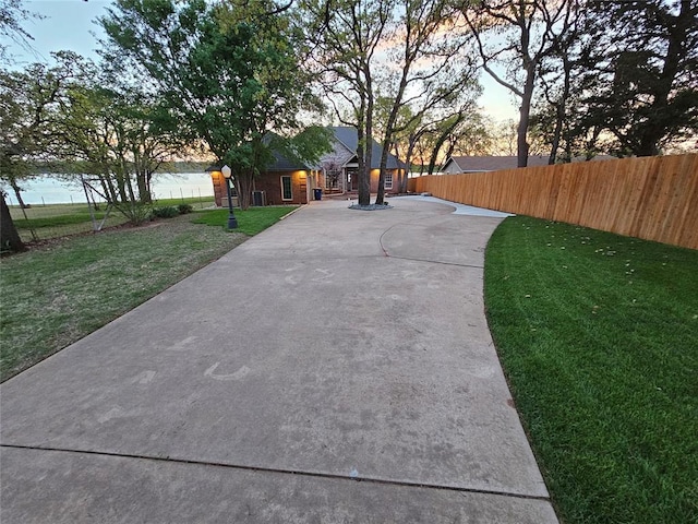 view of community with a lawn and fence