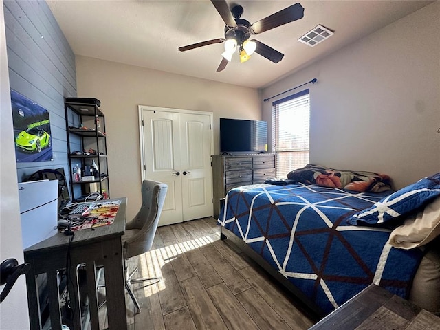 bedroom with visible vents, a ceiling fan, and wood finish floors