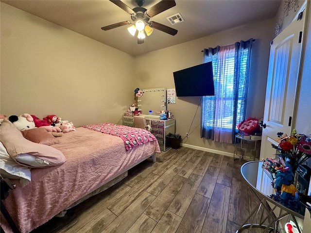 bedroom featuring multiple windows, visible vents, baseboards, and wood finished floors