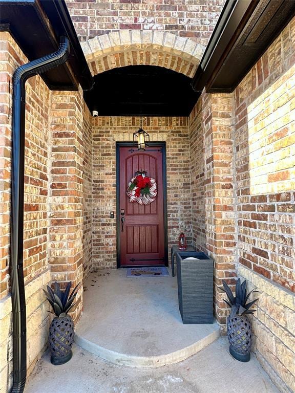 doorway to property with brick siding