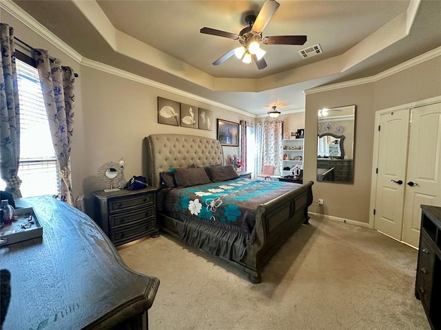 carpeted bedroom featuring ceiling fan, visible vents, a raised ceiling, and crown molding