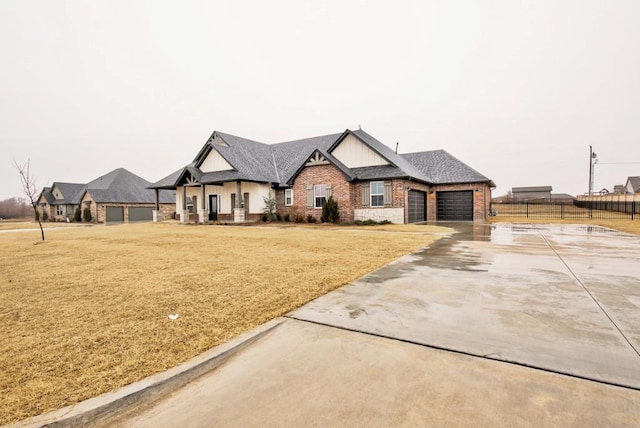 view of front of property featuring an attached garage, brick siding, fence, concrete driveway, and a front yard