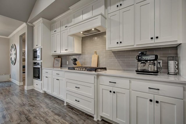 kitchen featuring appliances with stainless steel finishes, white cabinets, crown molding, and light countertops