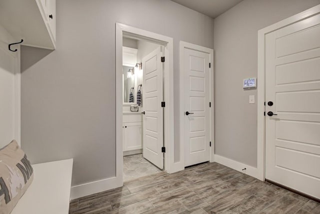 mudroom with wood finished floors and baseboards