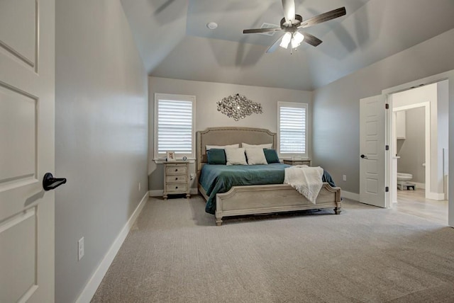 bedroom featuring carpet floors, vaulted ceiling, ensuite bath, and baseboards