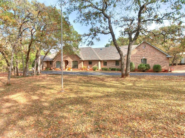 ranch-style house featuring brick siding and a front yard