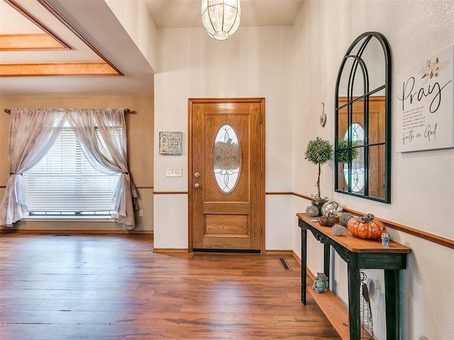 entryway featuring a healthy amount of sunlight, visible vents, baseboards, and wood finished floors