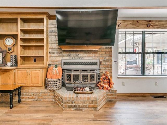 living area with visible vents, light wood-style flooring, and baseboards