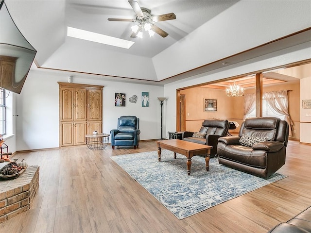 living room with ceiling fan, light wood finished floors, a skylight, and baseboards