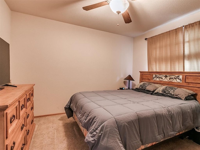 bedroom featuring light carpet, ceiling fan, and baseboards