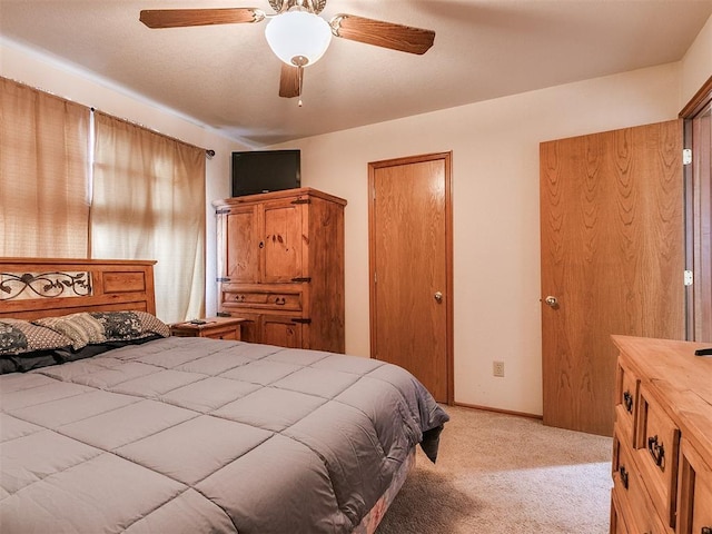 bedroom with ceiling fan, baseboards, and light colored carpet