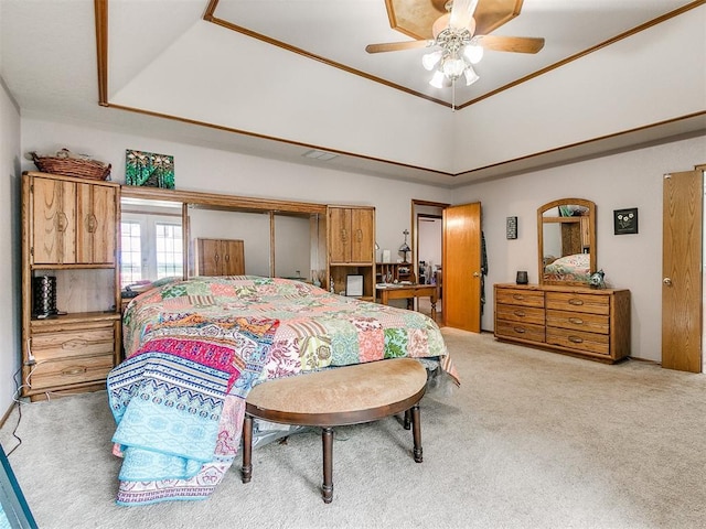 bedroom with a ceiling fan, carpet, visible vents, and a tray ceiling