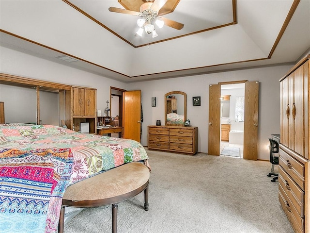 carpeted bedroom featuring a ceiling fan, a raised ceiling, and connected bathroom