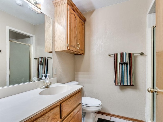 full bath with a textured wall, toilet, vanity, baseboards, and a shower stall