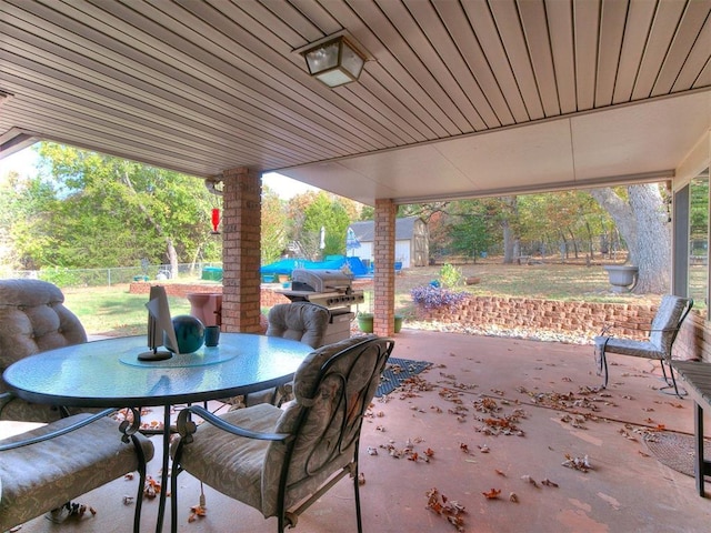 view of patio / terrace with an outbuilding, a storage shed, outdoor dining space, and a fenced backyard