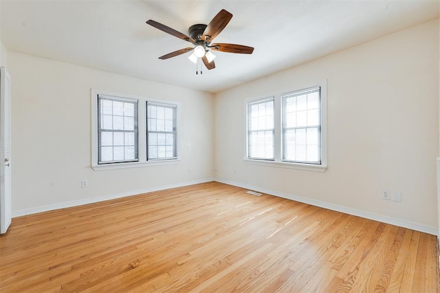 empty room featuring light wood-style floors, ceiling fan, and baseboards