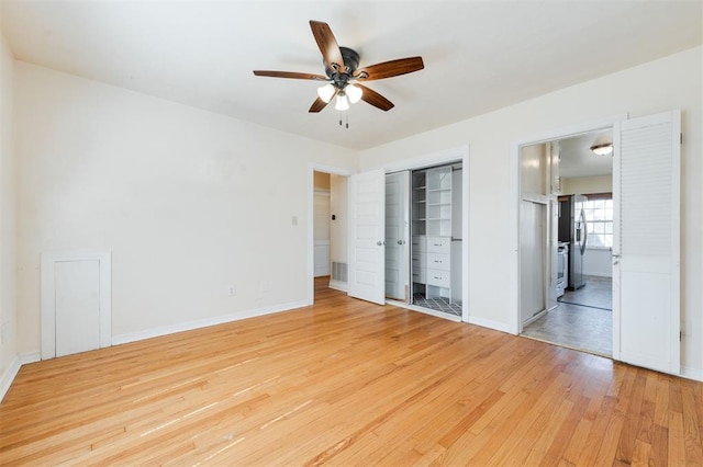 unfurnished bedroom with light wood finished floors, baseboards, a ceiling fan, connected bathroom, and stainless steel fridge with ice dispenser