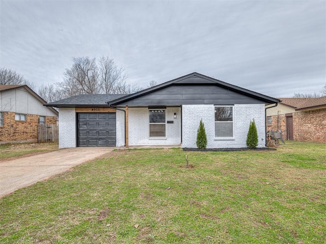 view of front of home with brick siding, a front yard, fence, a garage, and driveway