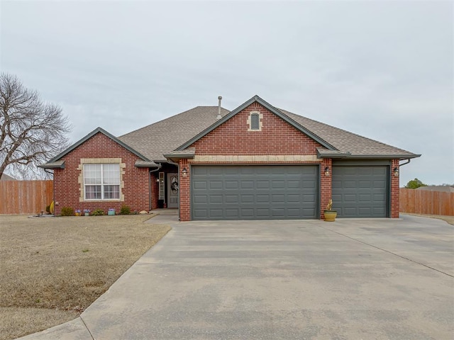 view of front of property with concrete driveway, brick siding, and fence