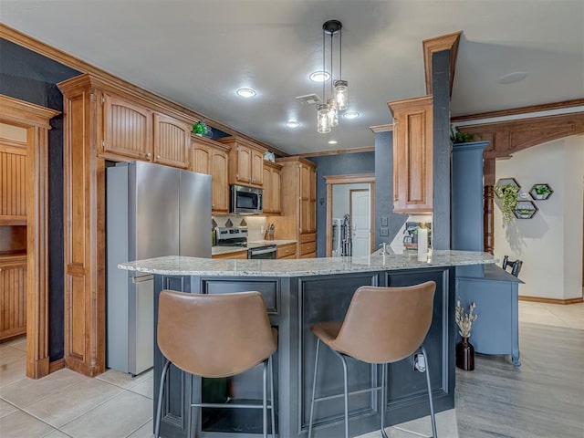 kitchen featuring light stone counters, crown molding, stainless steel appliances, visible vents, and a peninsula