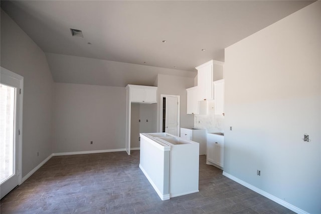3817 Lynne Ave, Edmond, OK 73012 - kitchen with white cabinetry, a kitchen island, wood finished floors, and vaulted ceiling