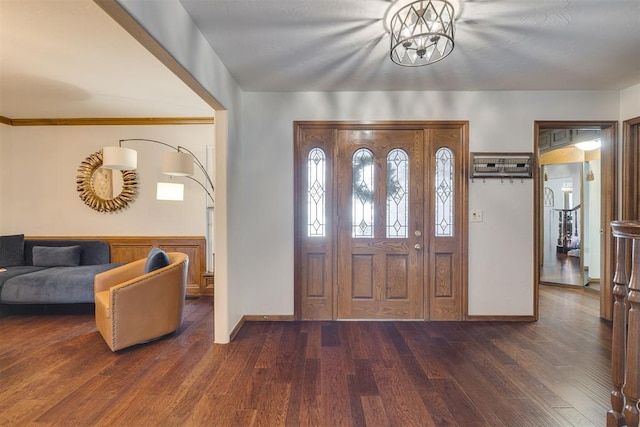 foyer with baseboards, a notable chandelier, and wood finished floors