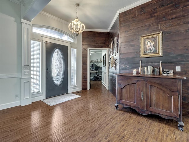 foyer entrance with crown molding, wood finished floors, and a healthy amount of sunlight