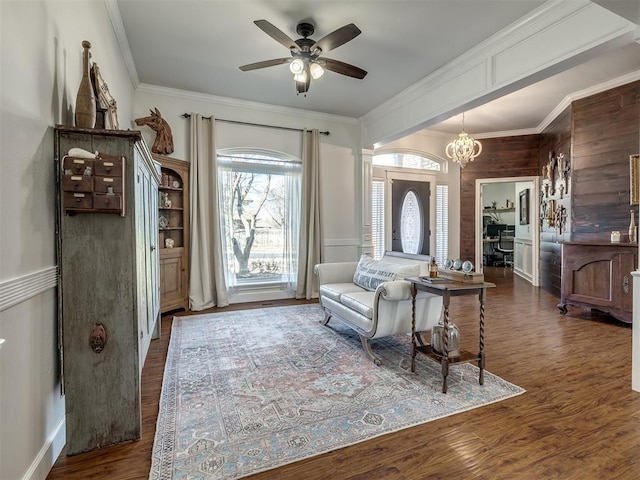 interior space with crown molding, wood finished floors, and ceiling fan with notable chandelier