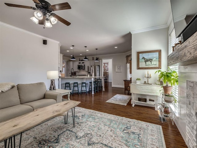 living room featuring dark wood-style flooring, crown molding, recessed lighting, a ceiling fan, and baseboards