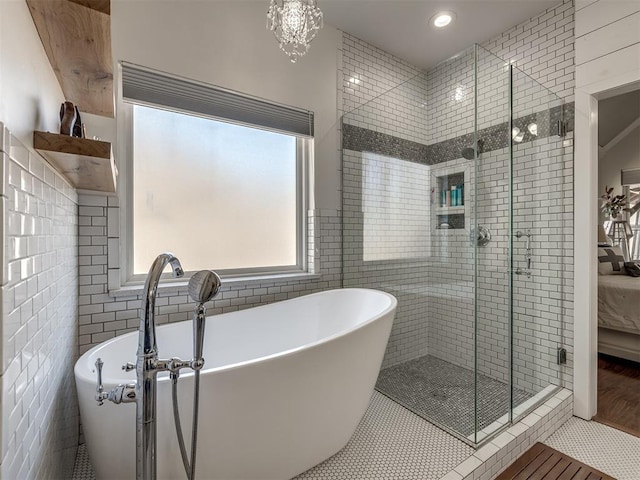 full bath featuring a freestanding bath, a stall shower, tile walls, and tile patterned floors