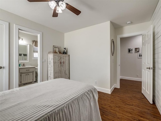 bedroom with a ceiling fan, ensuite bath, baseboards, and wood finished floors