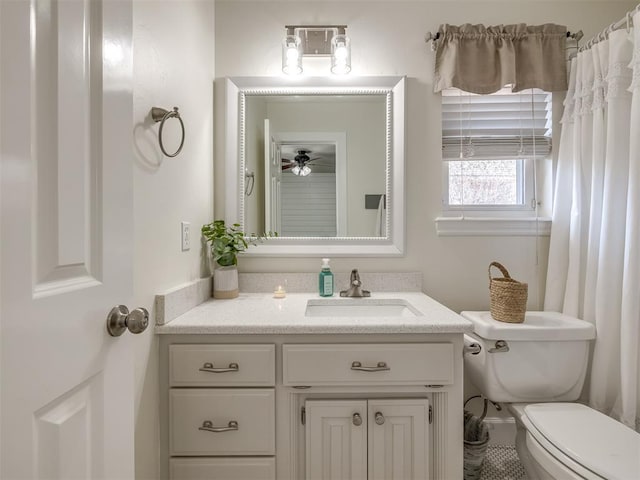 bathroom featuring toilet, a ceiling fan, and vanity