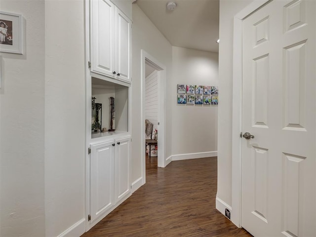 hall with dark wood finished floors and baseboards