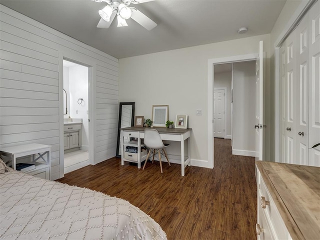 bedroom with connected bathroom, a closet, baseboards, and dark wood-type flooring