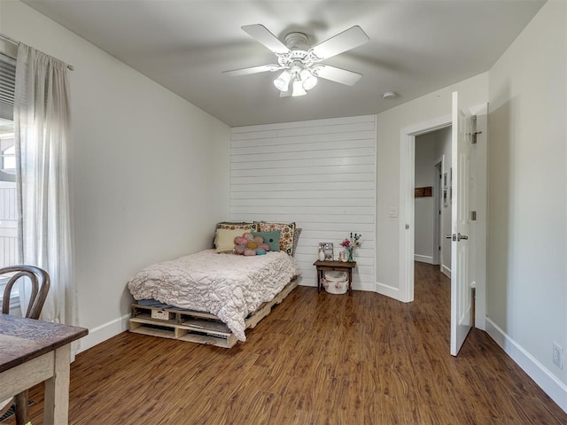 bedroom with ceiling fan, wood finished floors, and baseboards