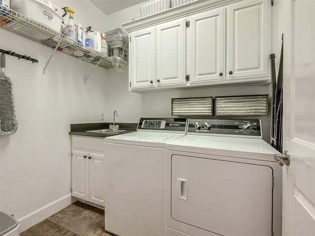 laundry room with cabinet space, baseboards, a sink, and independent washer and dryer