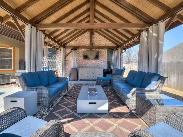 view of patio featuring an outdoor hangout area, a gazebo, exterior kitchen, and fence