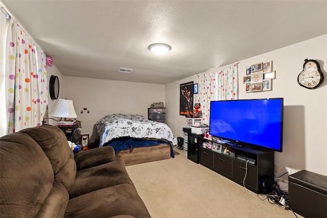 bedroom featuring carpet floors, visible vents, and a textured ceiling