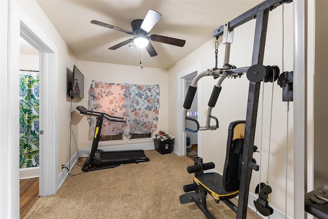 workout room featuring carpet, ceiling fan, a textured ceiling, and baseboards